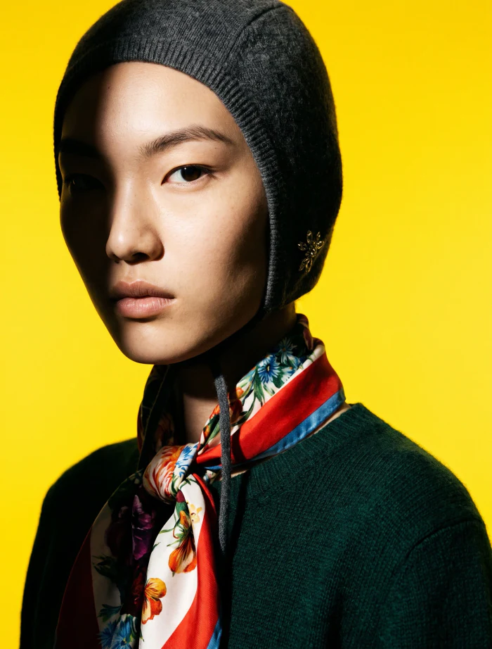 A silk scarf and knit beanie under hard light against a saturated yellow backdrop