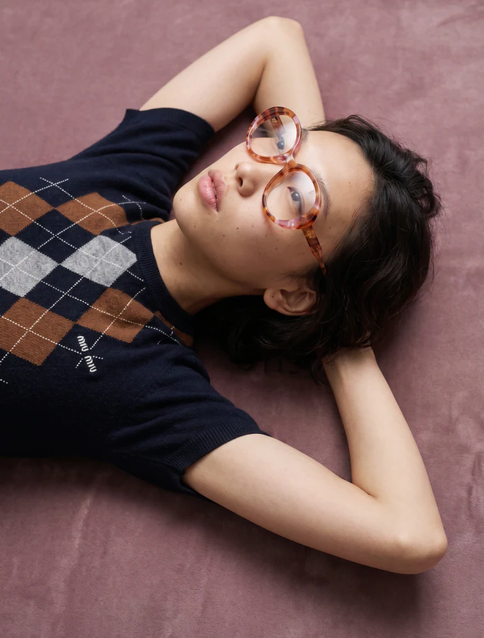An argyle knit and sculptural eyewear photographed straight overhead