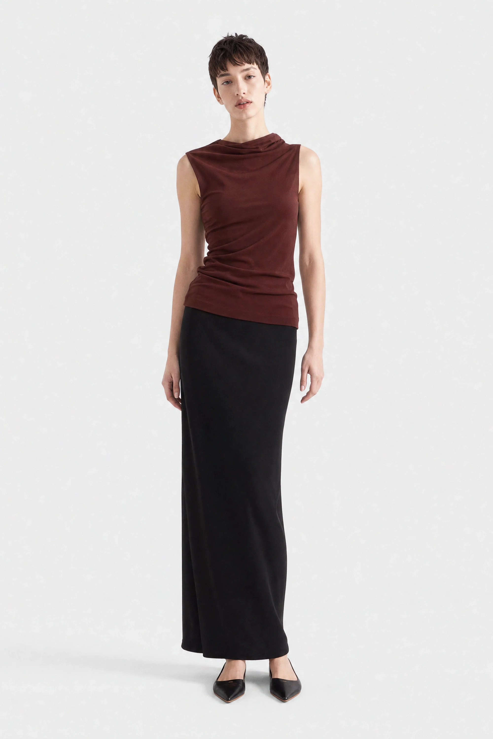 A knitted top and skirt shown worn on a plain background