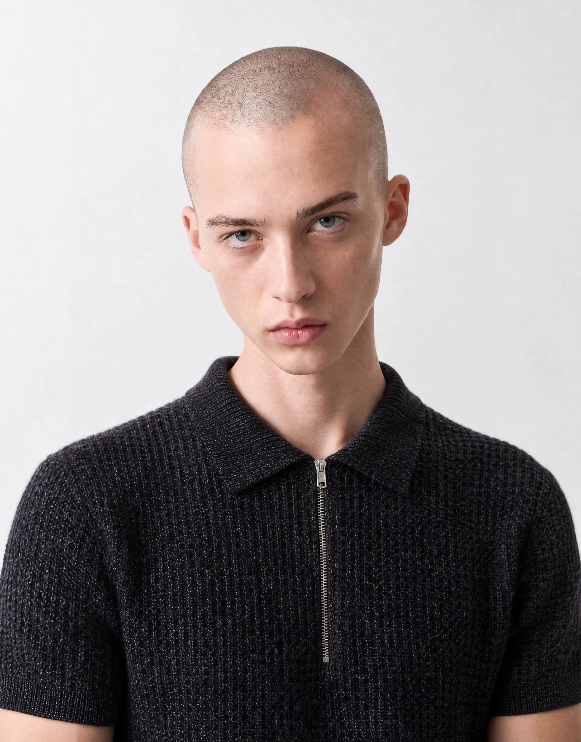 Close-up of a knitted polo showing stitch structure and zip hardware
