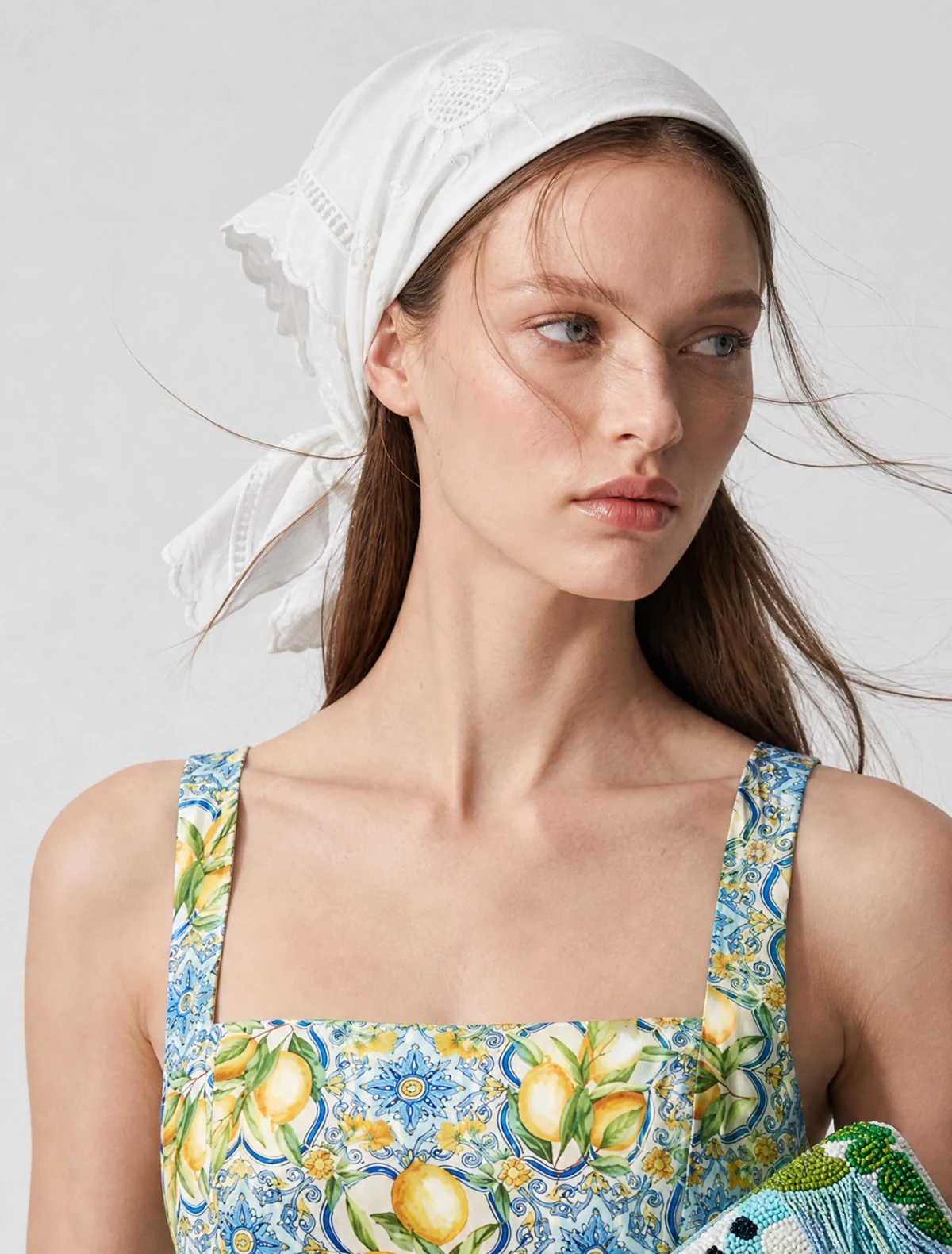 AI-generated on-model image: white headscarf with a floral bustier and a printed tote, mid shot
