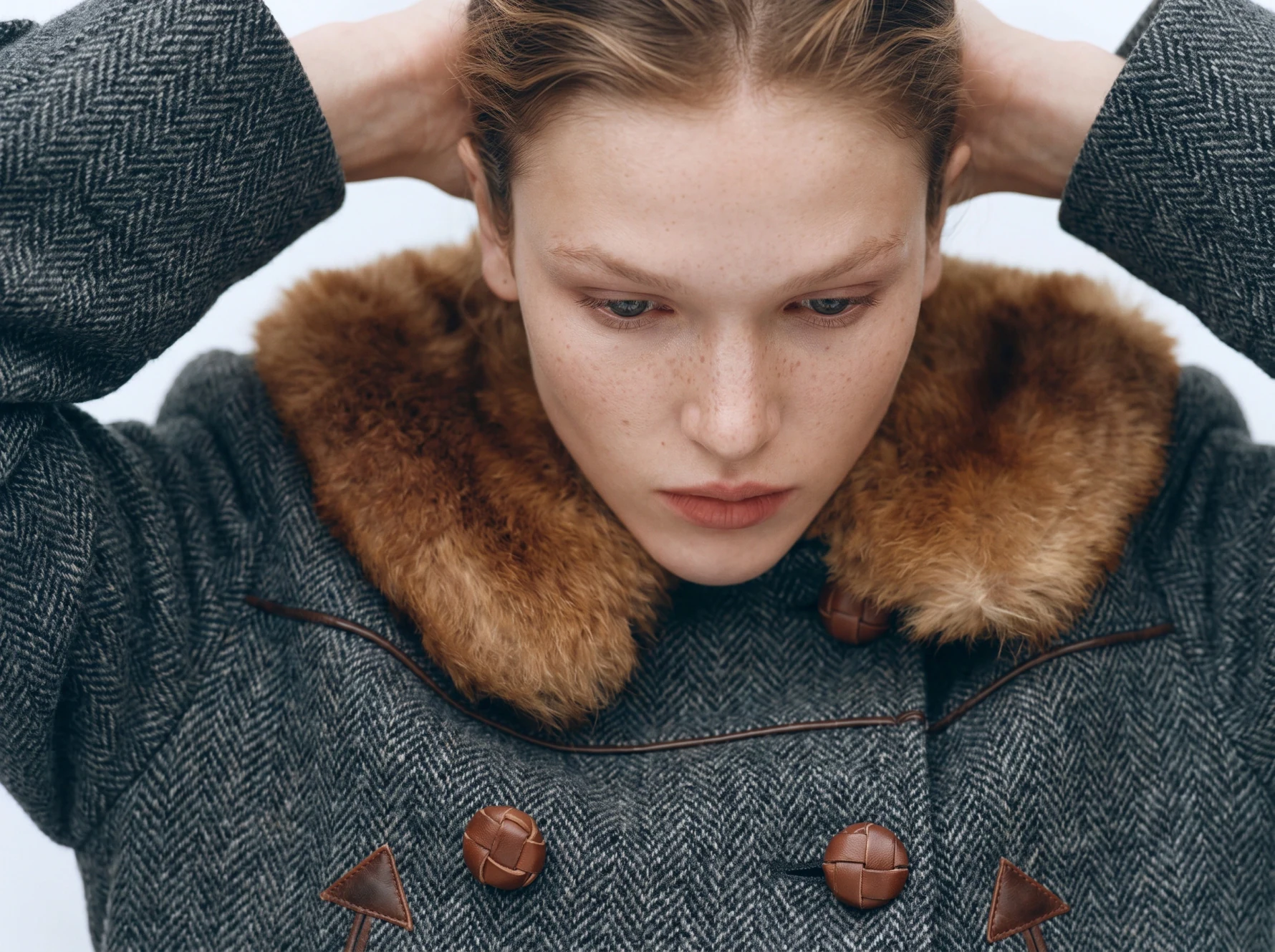 Herringbone coat with a fur collar — weave, buttons, and texture reproduced exactly on-model